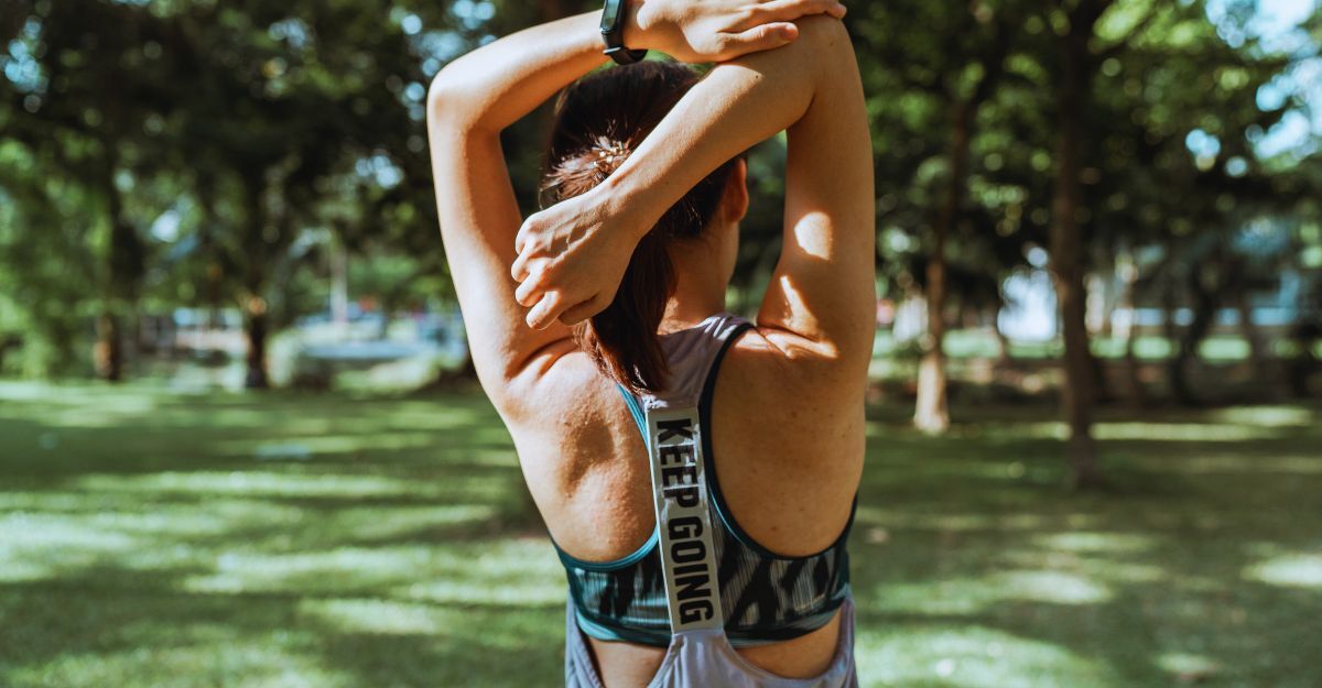 Donna che esegue esercizi di stretching all’aperto, utile come fase preparatoria al rilassamento isometrico