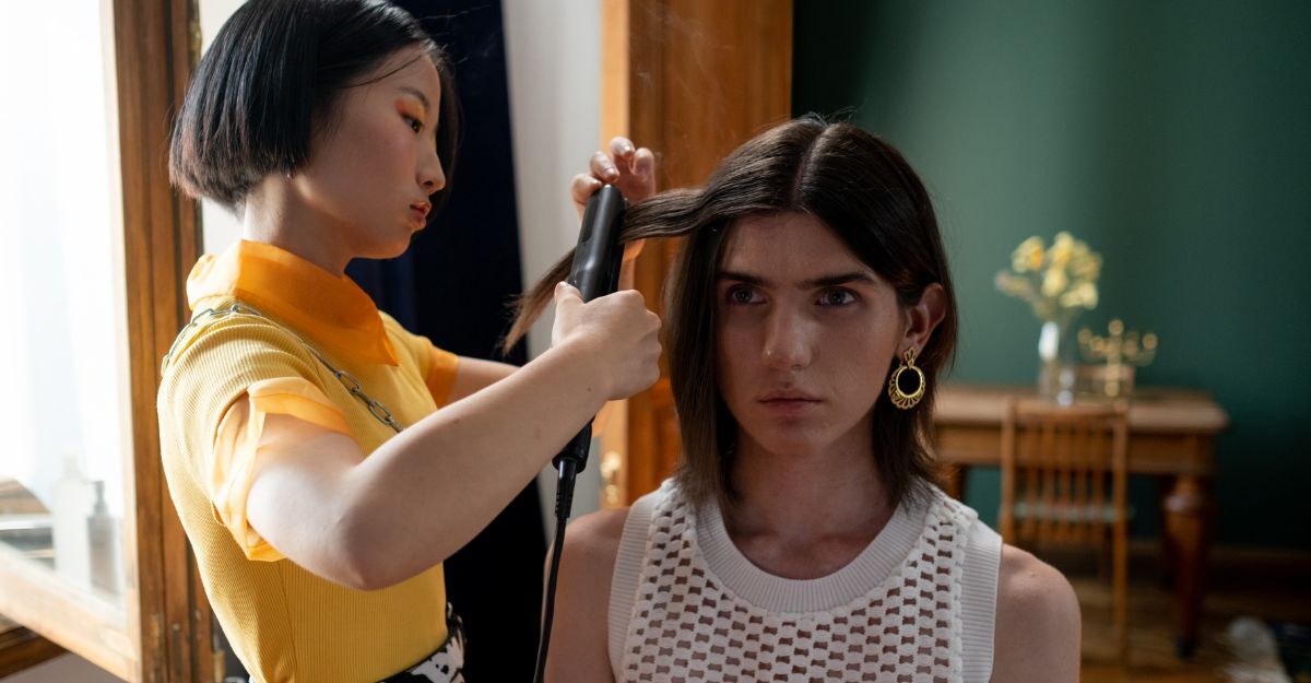 Una ragazza che piastra i capelli ad un'altra ragazza