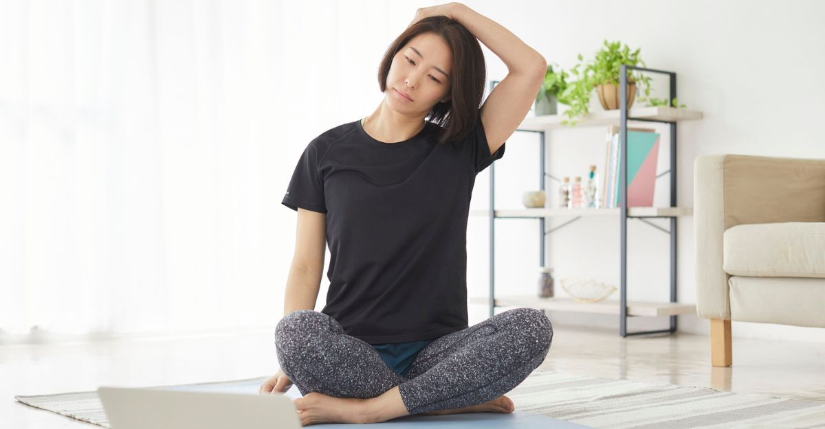 Donna seduta fa stretching al collo