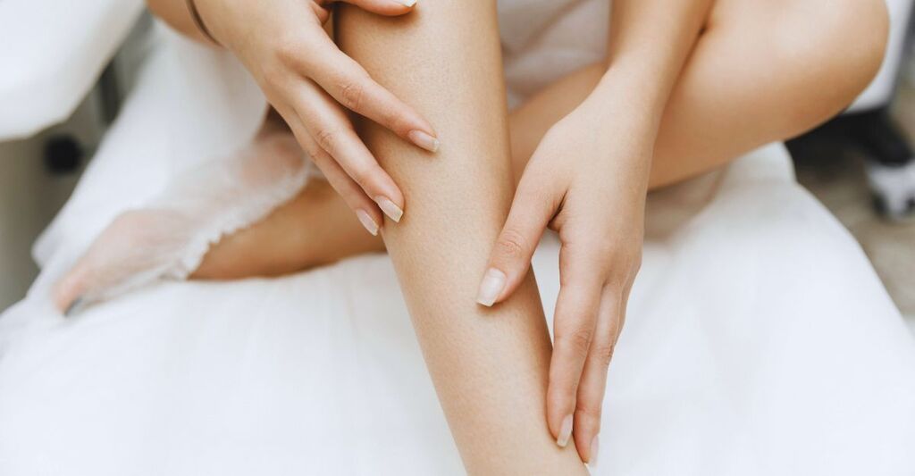 Mani di una donna che tocca le proprie gambe