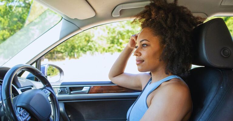 Donna in macchina che riflette sulla vita