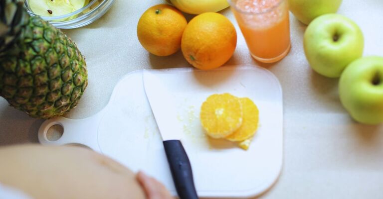 Donna incinta taglia arance su un tagliere