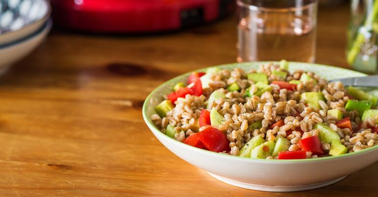 Piatto di farro condito con verdure su un tavolo da pranzo