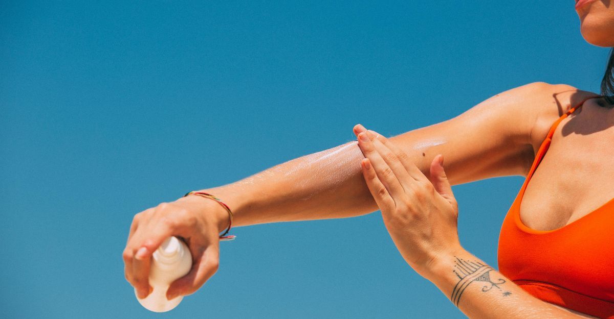 Ragazza che spalma la crema solare sul braccio