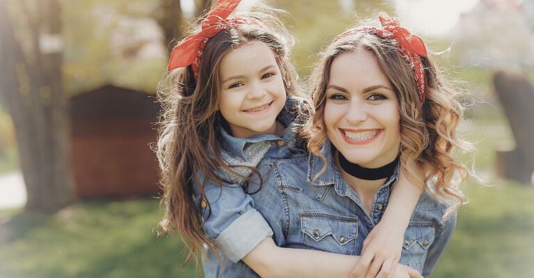 Una donna e una bambina indossano una fascia per capelli rossa