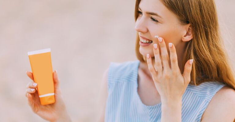 Donna che applica la crema sul viso