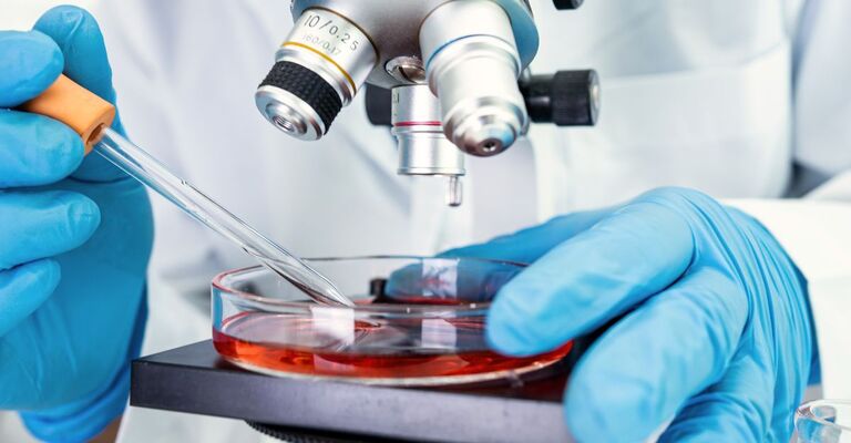 Un medico fa una ricerca al microscopio