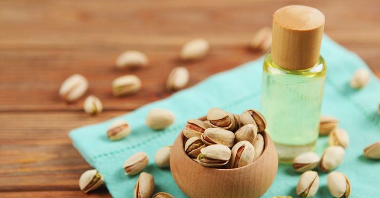 Olio di pistacchio e ciotola di pistacchi su un tavolo