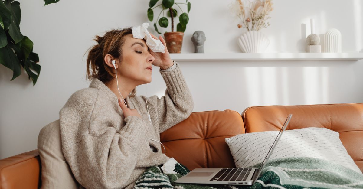 Una ragazza seduta sul divano che si asciuga il sudore