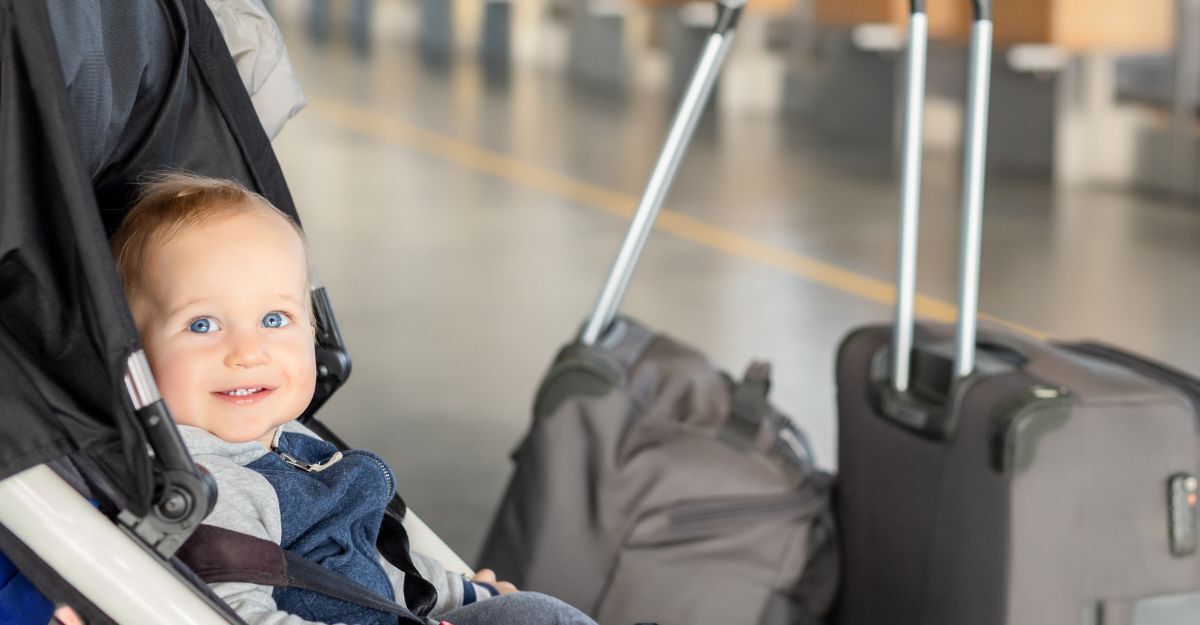 neonato sorridente sul passeggino in aeroporto