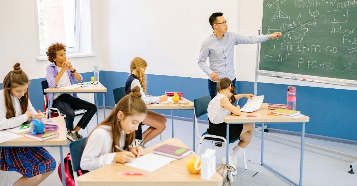 Classe di bambini con insegnante alla lavagna
