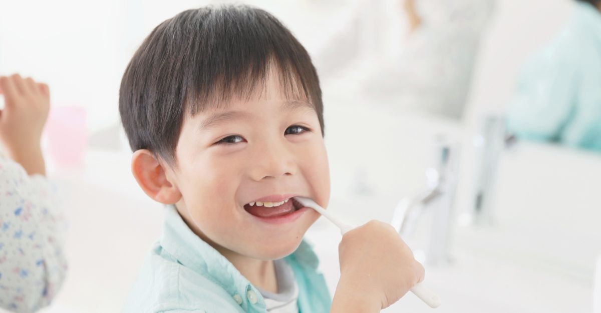 Un bambino si lava i denti e sorride