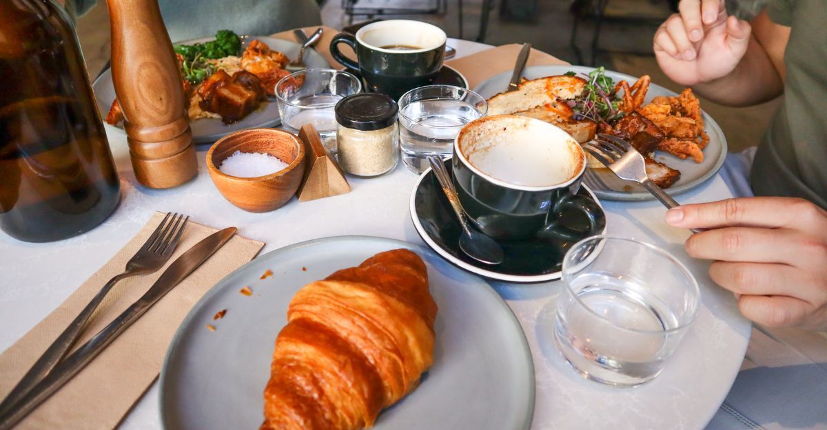 persona fa colazione con brioches, cappuccino e salato
