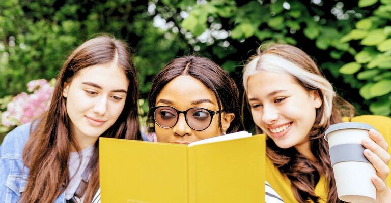 Tre ragazze che leggono insieme un libro