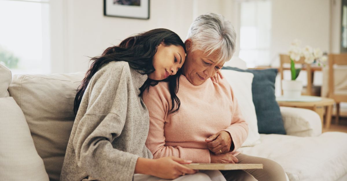Mamma e figlia sul divano che guardano una foto mente sono tristi 