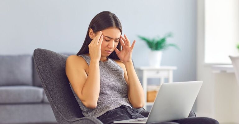 Una donna sofferente si tiene la testa