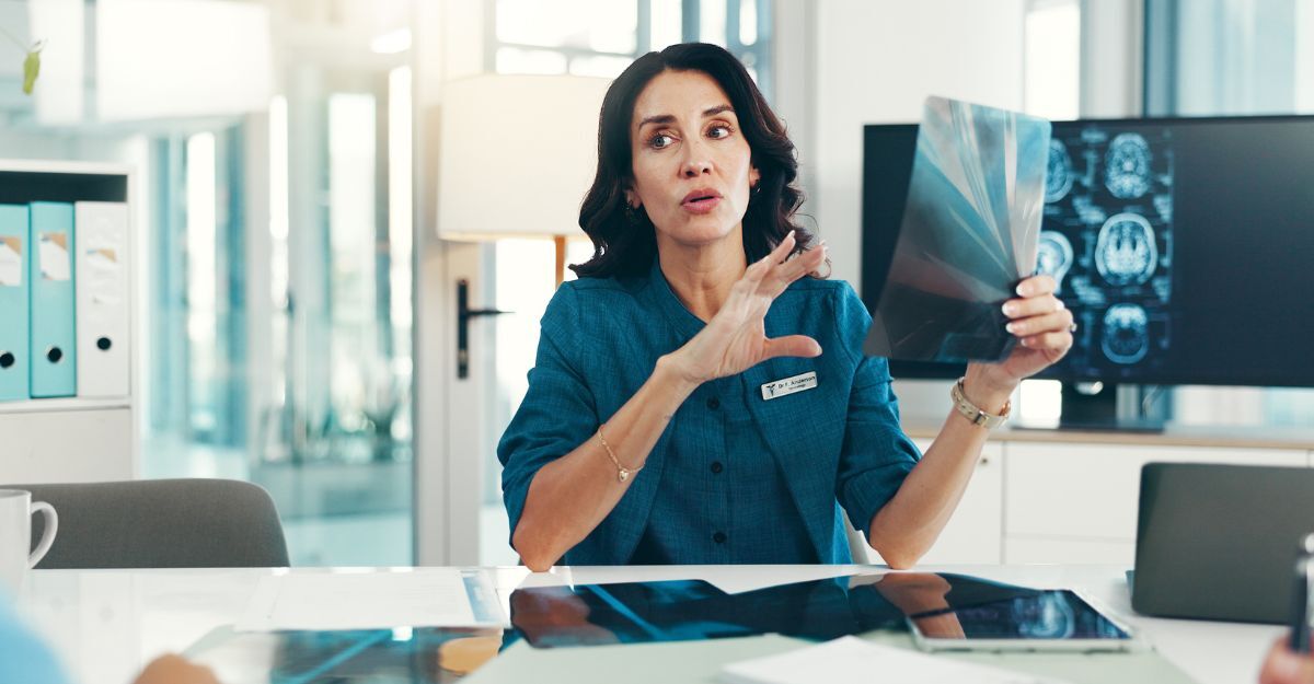 Neurologa che mostra una lastra a una paziente in studio