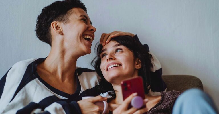 Una coppia di due donne che ride insieme con complicità