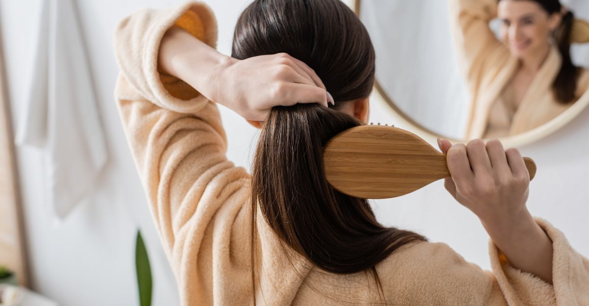 ragazza si pettina i capelli davanti allo specchio