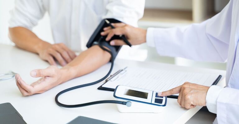 Un medico misura la pressione a un paziente