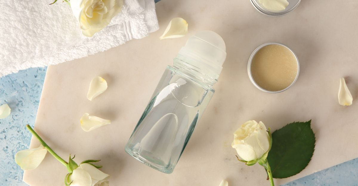 Un deodorante su un tavolo cosparso di petali.