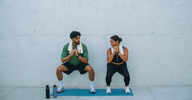 Due persone eseguono il wall squat.