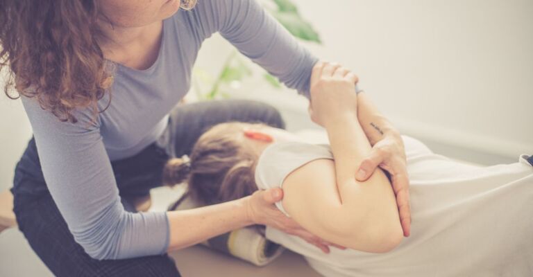 Operatrice Feldenkrais aiuta una persona durante una sessione individuale di rieducazione posturale.