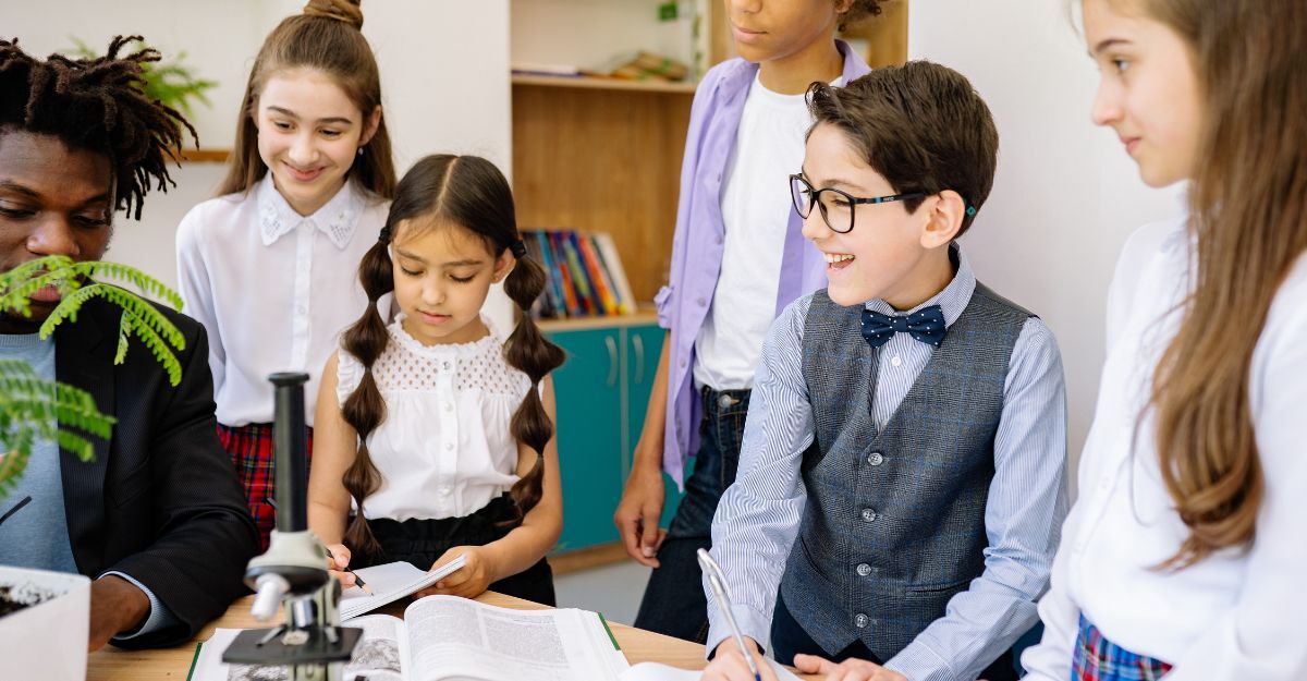 Un gruppo di studenti e un adulto attorno a un tavolo con libri e un microscopio.