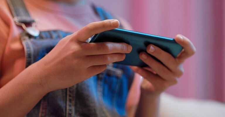 Una bambina utilizza lo smartphone.