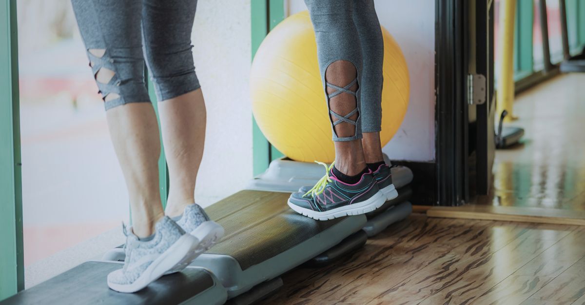 Due donne eseguono esercizi di stretching del polpaccio in palestra.