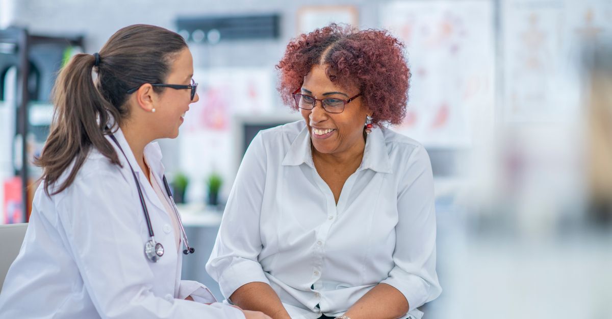 Una dottoressa parla con una paziente che sorride.
