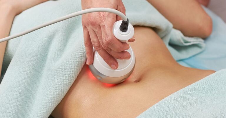 Operatrice che passa un macchinario a base di radiofrequenze sul busto di una cliente
