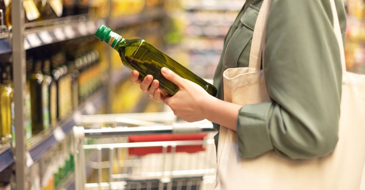 Primo piano di una donna che al supermercato valuta se comprare una bottiglia d'olio