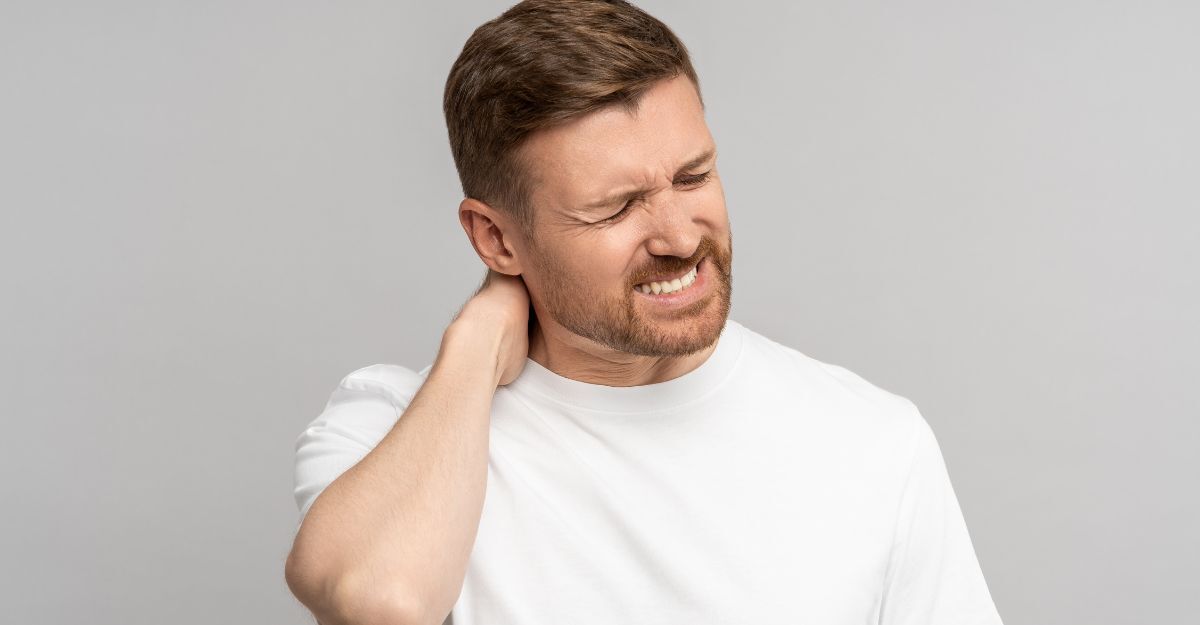 Uomo con dolore cervicale che si tocca il collo per la cervicobrachialgia