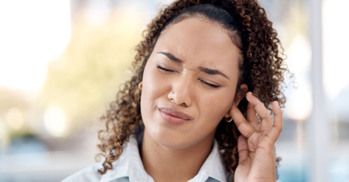 Giovane donna che si tocca l’orecchio per il disturbo da acufene.