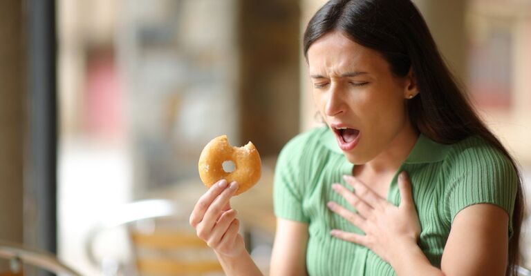 Una donna ha una reazione allergica mentre mangia.