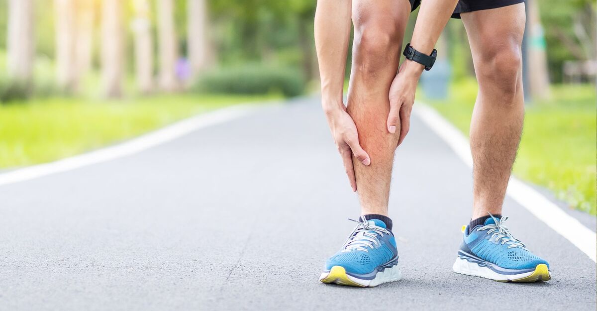 Un uomo si tiene lo stinco mentre fa sport.