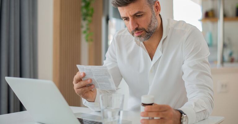 uomo seduto al pc controlla bugiardino medicina