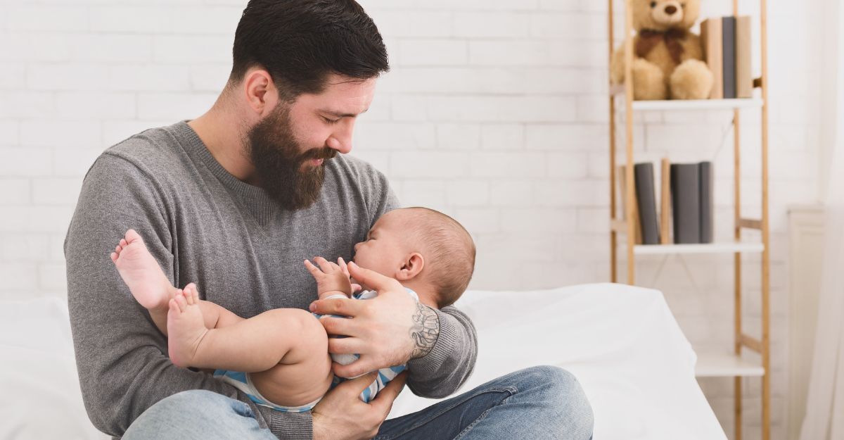 Un uomo tiene in braccio un neonato.