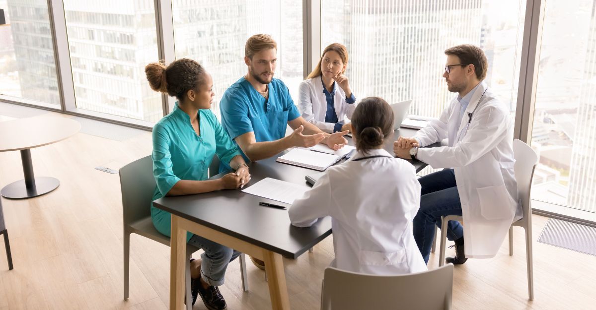 Gruppo di medici che discute fra di loro in merito alle novità in ambito medico in sala riunioni