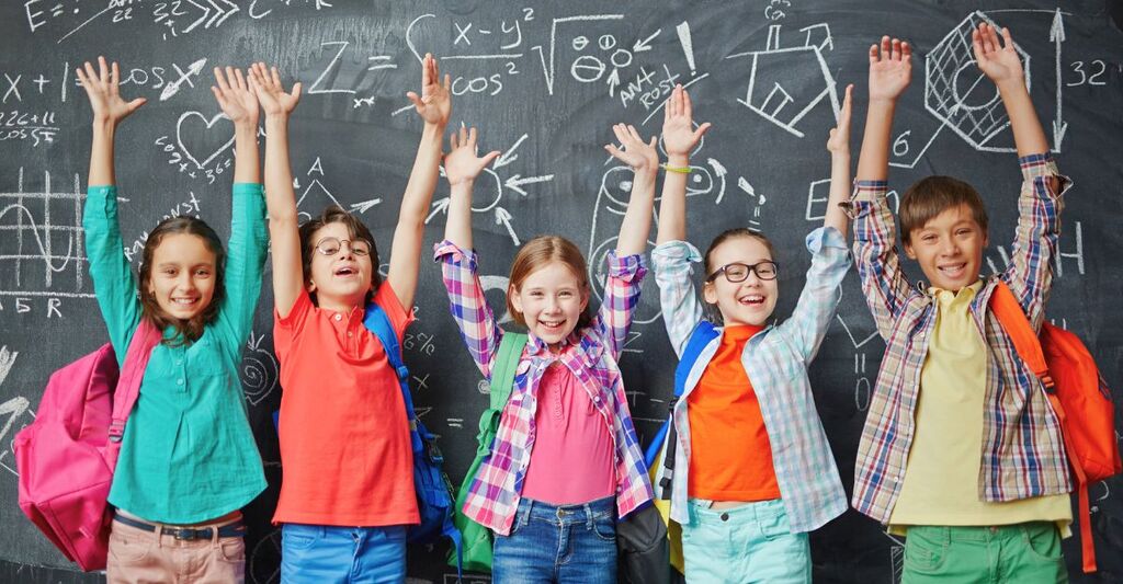 Un gruppo di bambini sorridenti a scuola.