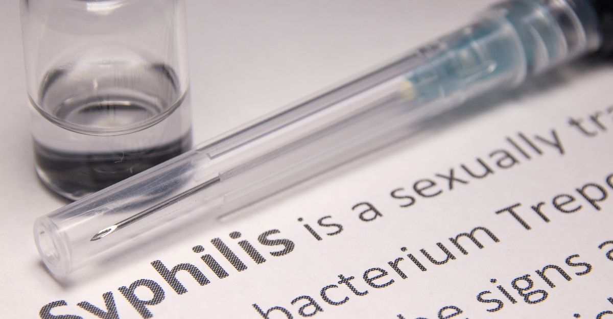 Siringa con farmaco e testo sulla sifilide, infezione sessualmente trasmissibile curata con penicillina