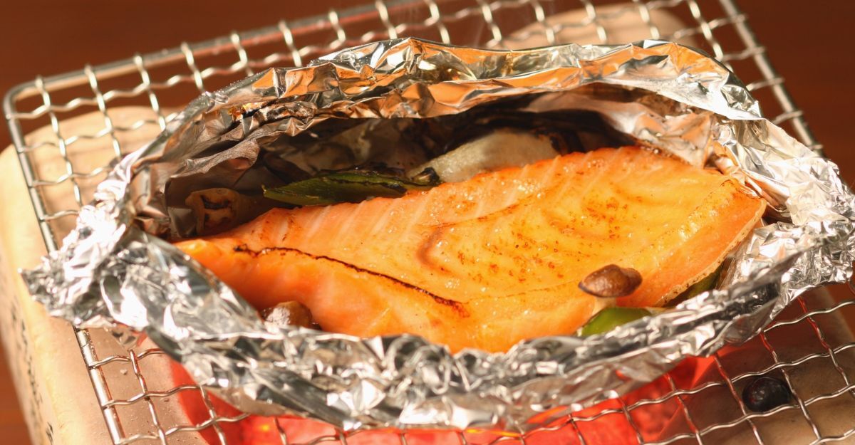 Pesce incartato nell'alluminio dentro una teglia da forno.