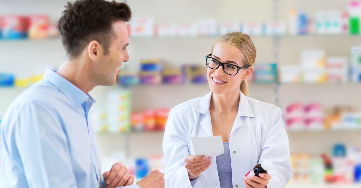 Un farmacista sorride e conversa con un cliente, tenendo in mano una bottiglia di medicinale e un foglio di istruzioni.