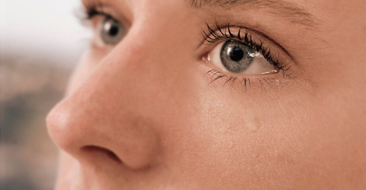 Primo piano del viso di una persona con gli occhi che lacrimano, con una lacrima che le scende lungo la guancia.