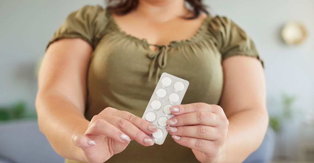 Una donna obesa tiene dei farmaci in mano.