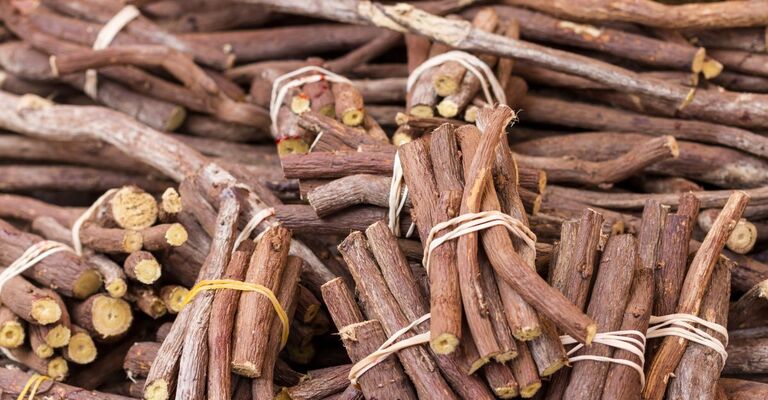 Primo piano di un grande mucchio di bastoncini di liquirizia grezza.