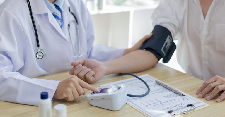 Un medico misura la pressione a un paziente.