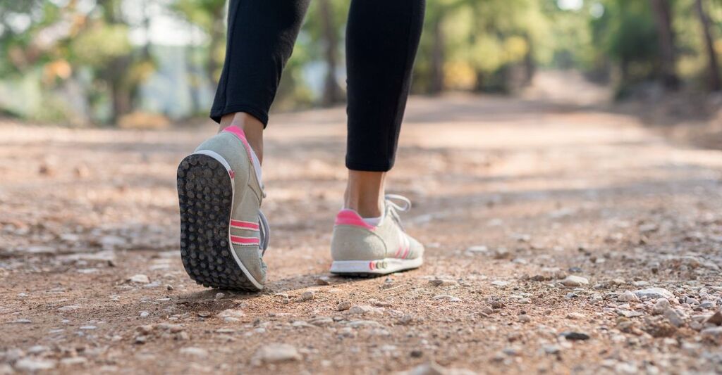 piedi di donna camminano su un sentiero