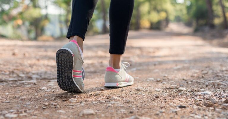 piedi di donna camminano su un sentiero